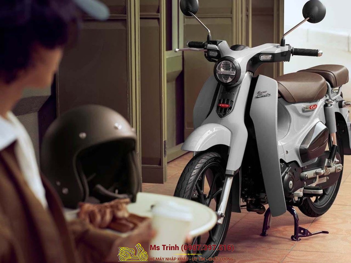 Honda Super Cub C125 ABS 2026 màu trắng kem đặt trong không gian nội thất sang trọng